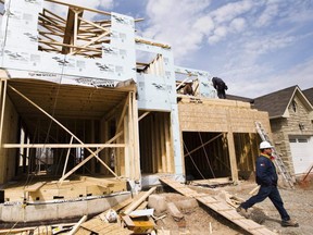 Construction workers build a new home in Oakville. (THE CANADIAN PRESS)