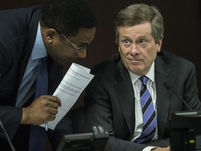 Councillor Michael Thompson (L) huddles with Mayor John Tory at a March 7 committee meeting. (CRAIG ROBERTSON, Toronto Sun)