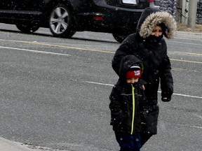 Hi winds and chilly temperatures prompted these pedestrians to bundle up last Wednesday on Kingston Rd., in Pickering. (VERONICA HENRI, Toronto Sun)