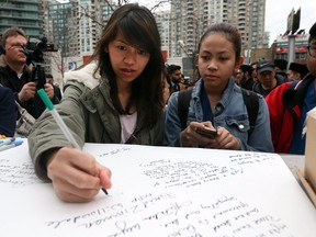 Residents write tributes at a growing memorial on Yonge St. a day after a van struck and killed 10 pedestrians and injured 15 more in Toronto on Tuesday, April 24, 2018.