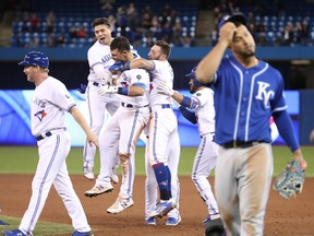 Toronto Blue Jays' Luke Maile (#21) is congratulated on his game-winning RBI single by Aledmys Diaz (#1) and Kevin Pillar (#11)during Tuesday's second game against the Kansas City Royals. (GETTY IMAGES)