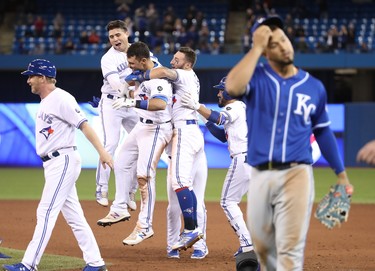 Toronto Blue Jays' Luke Maile (#21) is congratulated on his game-winning RBI single by Aledmys Diaz (#1) and Kevin Pillar (#11)during Tuesday's second game against the Kansas City Royals. (GETTY IMAGES)