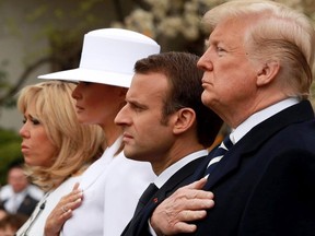 U.S. President Donald Trump (R) and French President Emmanuel Macron (2nd R) listen to the national anthem of the United States during a state arrival ceremony at the White House April 24, 2018 in Washington, DC. Also pictured are U.S first lady Melania Trump (2nd L) and Macron's wife Brigitte (L).