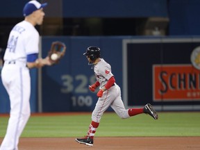 Mookie Betts #50 of the Boston Red Sox circles the bases after hitting a solo home run in the first inning off of Aaron Sanchez #41 of the Toronto Blue Jays at Rogers Centre on April 25, 2018 in Toronto, Canada. (Photo by Tom Szczerbowski/Getty Images)