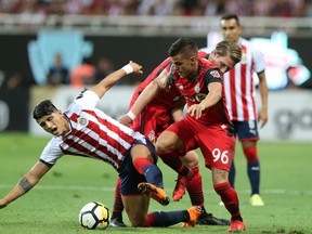 Chivas’ Alan Pulido fights for the ball with TFC’s Auro Junior during CONCACAF Champions League play. Refugio Ruiz/Getty Images
