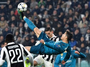 Real Madrid's Portuguese forward Cristiano Ronaldo (C) overhead kicks and scores during the UEFA Champions League quarter-final first leg football match between Juventus and Real Madrid at the Allianz Stadium in Turin on April 3, 2018. / AFP PHOTO / Alberto PIZZOLI