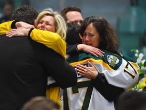 Mourners comfort each other during a vigil at the Elgar Petersen Arena, home of the Humboldt Broncos, to honour the victims of a fatal bus accident, April 8, 2018 in Humboldt, Canada. Mourners in the tiny Canadian town of Humboldt, still struggling to make sense of a devastating tragedy, prepared Sunday for a prayer vigil to honor the victims of the truck-bus crash that killed 15 of their own and shook North American ice hockey.  / AFP PHOTO / POOL / JONATHAN HAYWARDJONATHAN HAYWARD/AFP/Getty Images