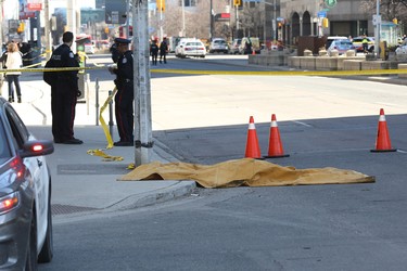 Police officers stand near a body that is covered up after it was hit after a truck drove up on the curb and hit several pedestrians in Toronto, Ontario, on April 23, 2018.  A man drove a white rental van into a crowd of pedestrians in the center of Canada's biggest city Toronto on April 23, 2018,. LARS HAGBERG/AFP/Getty Images