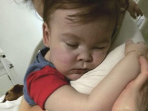 In this April 23, 2018 handout photo provided by Alfies Army Official, brain-damaged toddler Alfie Evans cuddles his mother Kate James at Alder Hey Hospital, Liverpool, England. (Alfies Army Official via AP)