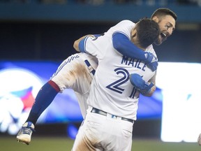 Toronto Blue Jays catcher Luke Maile is embraced by teammate Kevin Pillar after he hit a single in the tenth inning to drive Pillar home and defeat the Kansas City Royals in the second game of their American League MLB double header, in Toronto on Tuesday, April 17, 2018. THE CANADIAN PRESS/Fred Thornhill