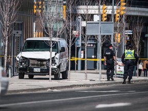 Toronto Police are seen near a damaged van in Toronto after a rental van hit pedestrians along Yonge St. on April 23, 2018. (CP)