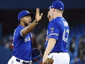 Toronto Blue Jays left fielder Teoscar Hernandez, left, and Blue Jays relief pitcher Aaron Loup (62) celebrate after defeating the Texas Rangers in AL baseball action in Toronto on Sunday, April 29, 2018. THE CANADIAN PRESS/Nathan Denette