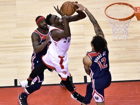Washington Wizards forward Kelly Oubre Jr. (12) puts the stop on Toronto Raptors forward Pascal Siakam (43) as teammate Ty Lawson (4) looks on during second half NBA basketball action in Toronto on Tuesday, April 17, 2018. THE CANADIAN PRESS/Frank Gunn ORG XMIT: GAC539