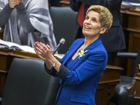 Ontario Premier Kathleen Wynne applauds while Ontario Finance Minister Charles Sousa (not pictured) delivers the provincial budget at the Ontario Legislature in Toronto, Ont. on Wednesday March 28, 2018.