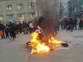 A man is seen in a Facebook video burning clothing in Yonge-Dundas Square.