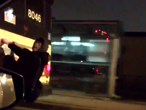 A man is seen hitching a ride at the back of a TTC bus in a video uploaded Thursday.