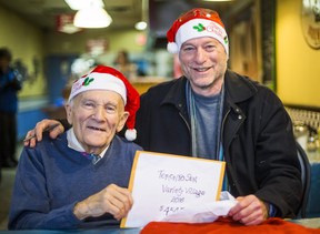 The late Mort Greenberg (left) presents a cheque to Toronto Sun columnist Mike Strobel for his Christmas Fund in Toronto, Ont. on December 21, 2016. (Ernest Doroszuk/Toronto Sun)