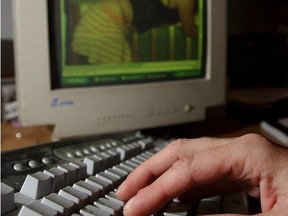 Man with hands on computer keyboard with picture of young girl on computer.