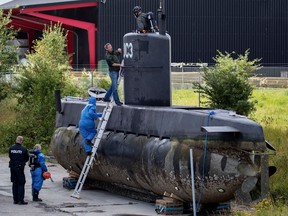 FILE - This is a Sunday, Aug. 13, 2017, file photo of police technicians board Peter Madsen's submarine UC3 Nautilus on a pier in Copenhagen harbour, Denmark. One of the most talked-about and macabre court cases in recent Danish history is set to conclude Wednesday, April 25, 2018 when the verdict is handed down on whether Peter Madsen tortured and murdered a Swedish journalist during a private submarine trip.