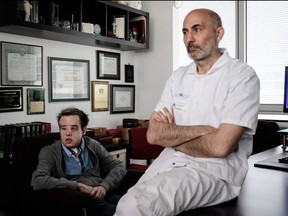 French medicine professor Laurent Lantieri (R), a specialist in hand and face transplant, poses with his patient Jerome Hamon.