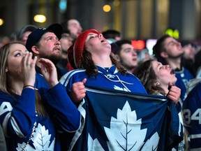 Fans react as they watch the Toronto Maple Leafs play the Boston Bruins on a large TV screen at Maple Leaf Square in Toronto, Wednesday, April 25, 2018. The Bruins stormed back to defeat the Toronto Maple Leafs 7-4 on Wednesday in Game 7 to advance to the second round of the Stanley Cup playoffs. THE CANADIAN PRESS/Galit Rodan