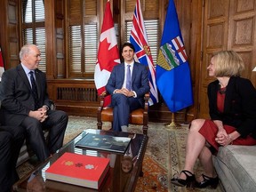 Prime Minister Justin Trudeau, B.C. Premier John Horgan, left, and Alberta Premier Rachel Notley, sit in Trudeau's office on Parliament Hill for a meeting on the deadlock over Kinder Morgan's Trans Mountain pipeline expansion, in Ottawa on Sunday, April 15, 2018. (THE CANADIAN PRESS/Justin Tang)