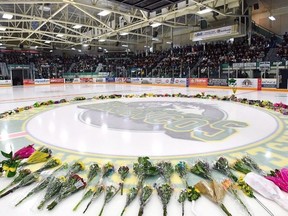 Flowers lie at centre ice as people gather for a vigil at the Elgar Petersen Arena, home of the Humboldt Broncos, to honour the victims of a fatal bus accident in Humboldt, Sask. on Sunday, April 8, 2018.