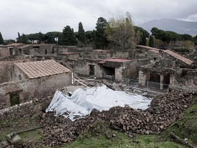 In this Wednesday, Nov. 10, 2010 file photo, debris of the collapsed house, once used by gladiators to train before combat, is protected from rain in the ancient Roman city of Pompeii, Italy.