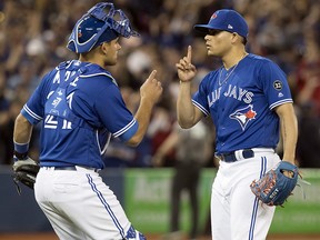 Toronto Blue Jays closer Roberto Osuna and catcher Luke Maile celebrate their win over the New York Yankees in Toronto on March 31, 2018