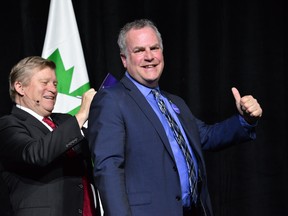 At the OHBA Industry Leaders dinner on Monday, April 16, keynote speaker Tom Clark signs the I am a #home believer pledge card on the back of OHBA president Pierre Dufresne.