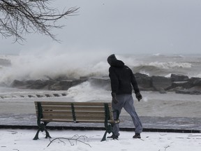 A man navigates 100 km/h. winds on the boardwalk in The Beach, as an April ice storm hits Toronto with high winds  and the danger of flooding,  on Sunday April 15, 2018. Stan Behal/Toronto Sun/Postmedia Network