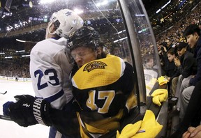 Boston Bruins’ Torey Krug (47) is checked into the boards by Toronto Maple Leafs’ Travis Dermott during the third period of Boston’s 7-3 win in Game 2 of an NHL hockey first-round playoff series in Boston Saturday, April 14, 2018. (AP Photo/Winslow Townson)