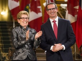 Former Ontario Premiere Dalton McGuinty laughs with Ontario Premier Kathleen Wynne before McGuinty’s official portrait is unveiled at Queen’s Park in Toronto Tuesday February 23, 2016.