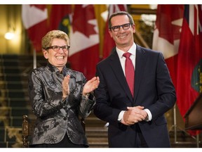 Former Ontario Premiere Dalton McGuinty laughs with Ontario Premier Kathleen Wynne before McGuinty's official portrait is unveiled at Queen's Park in Toronto Tuesday February 23, 2016.