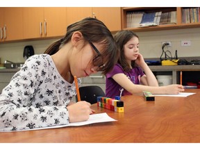 Pope John Paul II School students Ava Fobister (left) and Brianna Herbacz (right) write down surface area measurements during a math lesson on Friday, Jan. 13. The Kenora Catholic District School Board said it is working on an action plan for mathematics based on EQAO test results from 2016/17. FILE PHOTO ORG XMIT: POS1701151429242346