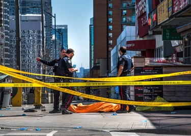 A body lies covered on the sidewalk in Toronto after a van mounted a sidewalk crashing into a number of pedestrians on Monday, April 23, 2018. THE CANADIAN PRESS/Aaron Vincent Elkaim