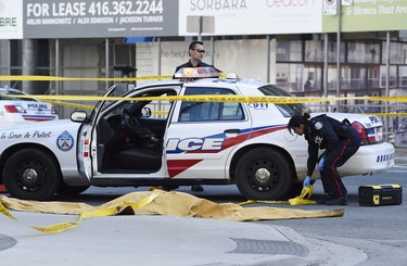 Police officers secure an area around a covered body in Toronto after a van mounted a sidewalk crashing into a number of pedestrians on Monday, April 23, 2018. THE CANADIAN PRESS/Nathan Denette