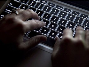A woman uses her computer keyboard to type while surfing the internet in North Vancouver on Dec., 19, 2012.
