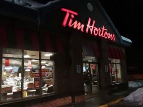 A customer walks out of a Tim Hortons restaurant in Newcastle, Ont., on Sunday Feb. 11, 2018. THE CANADIAN PRESS/Doug Ives