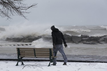 A man navigates 100 km. winds on the boardwalk in The Beach, as an April ice storm hits Toronto with high winds  and the danger of flooding,  on Sunday April 15, 2018. Stan Behal/Toronto Sun/Postmedia Network