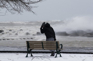 A man navigates 100 km. winds on the boardwalk in The Beach, as an April ice storm hits Toronto with high winds  and the danger of flooding,  on Sunday April 15, 2018. Stan Behal/Toronto Sun/Postmedia Network