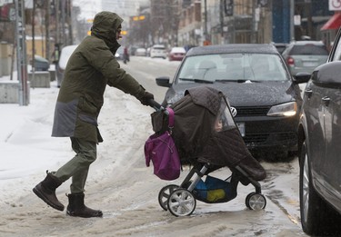 A pedestrian and his passenger navigate an icy Queen Street West, as an April ice storm hits Toronto with high winds  and the danger of flooding,  on Sunday April 15, 2018. Stan Behal/Toronto Sun/Postmedia Network