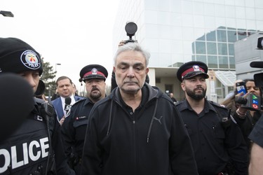 Vahe Minassian is escorted out of the 1000 Finch Court by police officers on  Tuesday April 24, 2018 after his son Alek Minassian was charged with 10 counts of first degree and 13 counts of attempted murder in the van attack on Yonge Street at Finch. (Stan Behal/Toronto Sun)