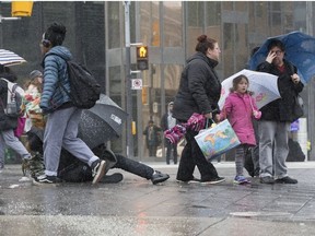 Pedestrians struggle in the cold and icy weather at Front and Bay Sts. on Saturday April 14, 2018.