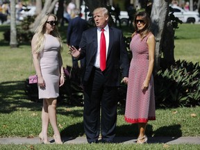 President Donald Trump stops to talk to members of the media as he arrives for Easter services with his daughter Tiffany Trump, left, and first lady Melania Trump, right, at Episcopal Church of Bethesda-by-the-Sea, Sunday, April 1, 2018, in Palm Beach, Fla.