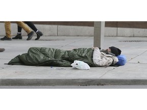 A  homeless street person sleeps at the corner of Bay and Queen Sts. on Thursday April 5, 2018. Veronica Henri/Toronto Sun/Postmedia Network