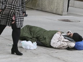 A  homeless street person sleeps at the corner of Bay and Queen Sts. on Thursday April 5, 2018.