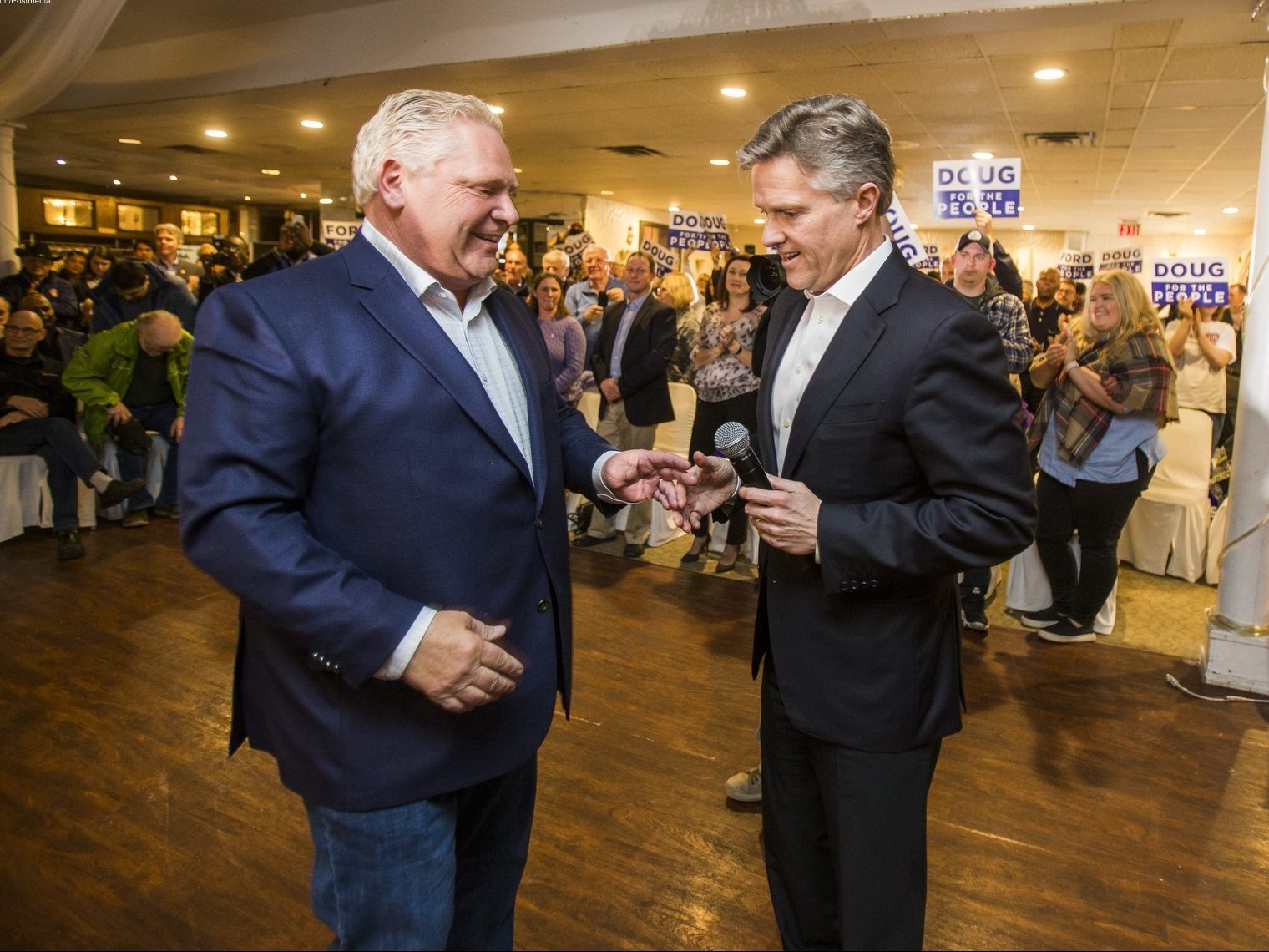  Premier Doug Ford, left, receives the microphone from Ontario PC candidate Rod Phillips at a campaign rally at La Roya Banquet Hall in Ajax, Ont., on Wednesday April 18, 2018. Ernest Doroszuk/Toronto Sun