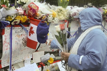 A steady stream of people stop to drop off flowers and read handwritten notes at a memorial wall at Yonge St and Finch Ave. on Wednesday April 25, 2018 after the deadly van attack in North York.Veronica Henri/Toronto Sun/Postmedia Network