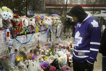 A steady stream of people stop to drop off flowers and read handwritten notes at a memorial wall at Yonge St and Finch Ave. on Wednesday April 25, 2018 after the deadly van attack in North York.Veronica Henri/Toronto Sun/Postmedia Network